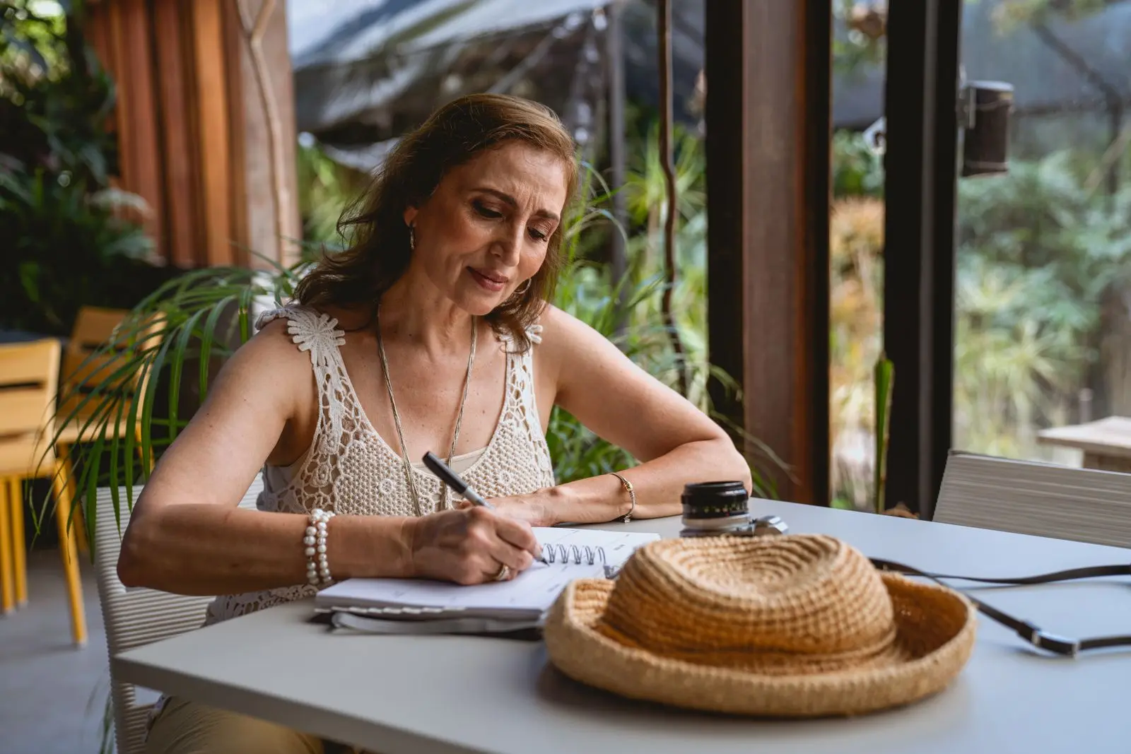 Writing trip notes in a notebook at a cafe table